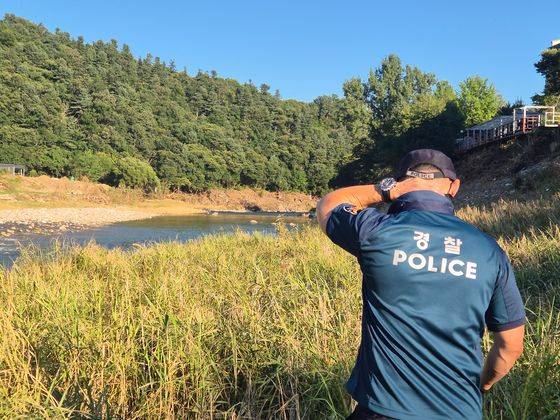 지난 27일 오후 5시쯤 경기 가평군 상면 덕현리 조종천계곡서 경기북부청 기동대원이 실종자 수색을 하던 도중 목 뒤의 땀을 훔치고 있다. 오소영 기자