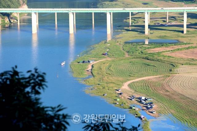 ▲ 지난 27일 폭염 속에 인제군 인제대교 아래에 위치한 소양호 변에서 낚시꾼들이 붕어낚시 삼매경에 빠져 있다.