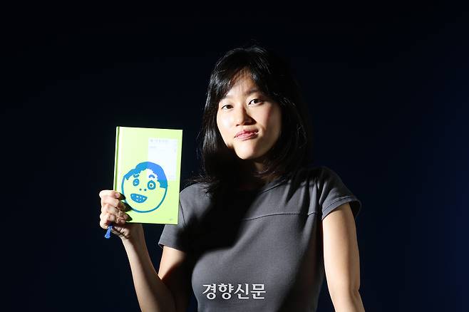 소설 <꽤 낙천적인 아이>의 저자 원소윤씨가 28일 인터뷰에 앞서 경향신문 스튜디오에서 책을 들고 포즈를 취하고 있다. 정지윤 선임기자