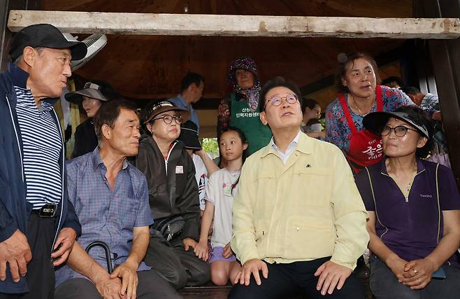 President Lee Jae Myung, second from right, talks to residents of Sancheong County, South Gyeongsang, on July 21, after heavy rainfall led to a landslide and flooding in the area. According to the National Barometer Survey (NBS) conducted by Embrain Public, KSTAT Research, Korea Research and Hankook Research from July 21 to 23 on 1,001 adults nationwide, 64 percent responded that President Lee Jae Myung is doing a good job as president. [JOINT PRESS CORPS]