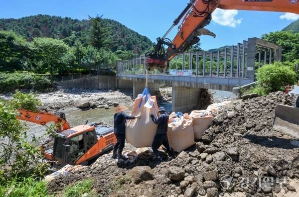 27일 가평군 가평읍 승안2교 일원에서 관계자들이 수해 복구를 하고 있다. 지난 폭우 이후 폭염이 계속되면서 도내 수해지역마다 복구 작업에 어려움을 겪고 있다. 윤원규기자