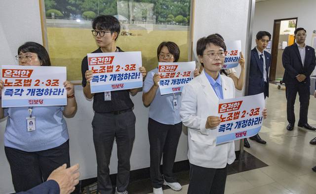 전종덕 진보당 의원이 28일 국회 환경노동위원회 법안소위가 열린 소회의실 앞에서 손팻말을 들고 여야 의원들에게 ‘온전한 노조법 2ㆍ3조(노란봉투법) 즉각 개정’을 촉구하고 있다. 연합뉴스