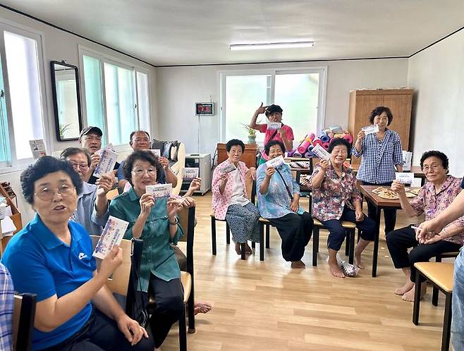 [보성=뉴시스] 21일 전남 보성군 보성읍 평촌경로당에서 주민들이 지급받은 민생회복 소비쿠폰을 들어보이고 있다. (사진 제공 = 보성군). 2025.07.21. photo@newsis.com  *재판매 및 DB 금지