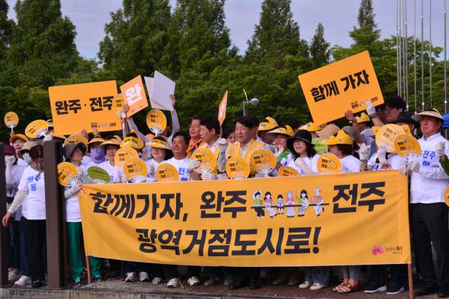 ▲28일 오전 우범기 전주시장이 통합 캠페인 참가자들과 함께 피켓을 들고 시민들에게 통합의 뜻을 전달하고 있다. ⓒ전주시