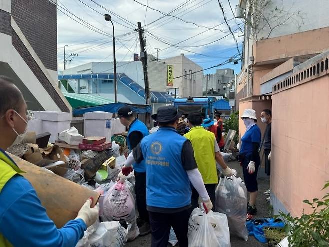 아산시와 관련 단체 관계자들이 저장강박 증상이 의심되는 집에서 주거환경개선사업을 펼치고 있다. 시 제공