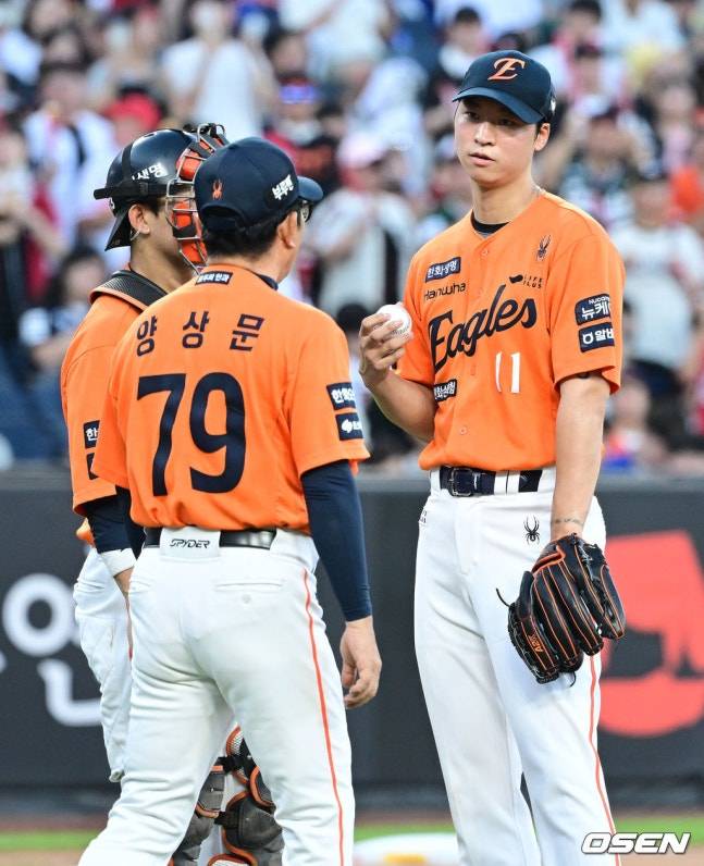 엄상백(오른쪽)이 양상문 투수코치와 이야기를 한 뒤 마운드에서 내려가고 있다.