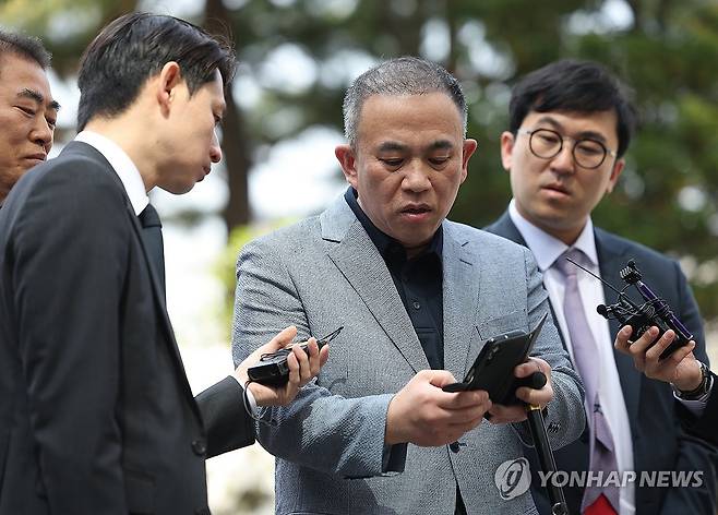 취재진에게 휴대전화 보여주는 명태균 씨 (서울=연합뉴스) 김성민 기자 = '정치 브로커' 명태균 씨가 30일 윤석열 전 대통령 부부와 구(舊)여권 정치인 다수가 연루된 공천 개입·여론조사 의혹 관련 조사를 받기 위해 서초구 서울고등검찰청으로 향하며 취재진의 질문에 답변하며 휴대전화를 들어 보이고 있다. 2025.4.30 ksm7976@yna.co.kr