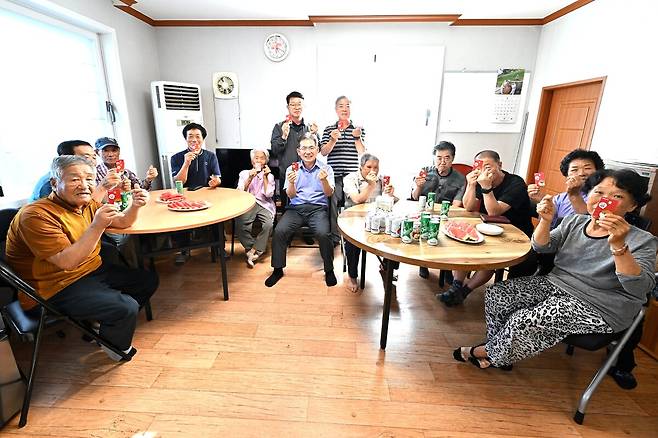 지난 28일 의흥면 금양2리 경로당 어르신들이 ‘찾아가는 소비쿠폰 신청 서비스’를 통해 발급받은 민생쿠폰 카드를 들어 보이고 있다(가운데 김진열 군위군수)./ 대구 군위군 제공