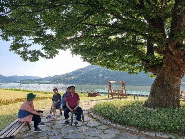 문학기행 중에 느티나무 그늘에서 쉬고 있는 문우들 ⓒ