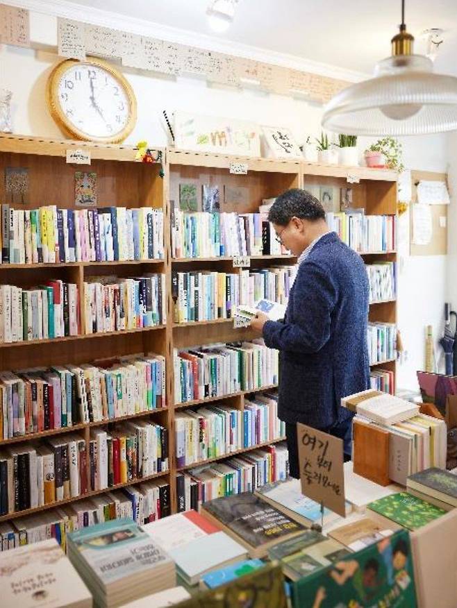 김동연 경기도지사가&nbsp;29일 오후 수원시 장안구 광화문서림 서점을 찾아 여름휴가 때 읽을 책을 고르고 있다, 김 지사는 민생회복 소비쿠폰을 지역화폐로 받아 책값을 계산했다. 경기도 제공