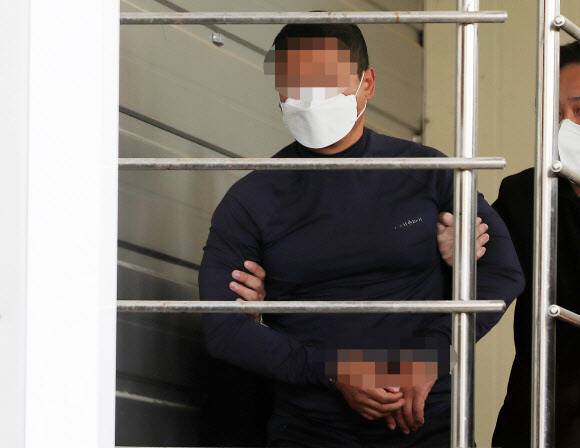 지난해 5월9일 오후 부산 연제경찰서에서 이날 오전 부산법조타운 인근에서 유튜버를 살해한 혐의를 받는 용의자 ㄱ씨가 압송되고 있다. 연합뉴스
