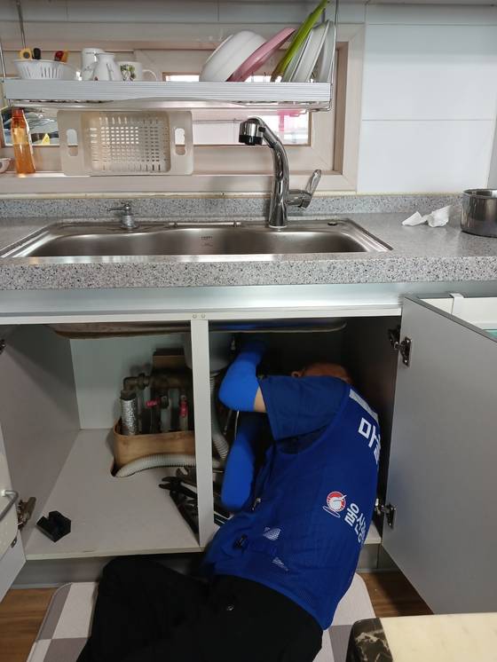 싱크대 아래 수전 작업을 하는 마을지킴이. 사진 울산 동구