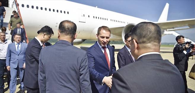 < 러 여객기, 승객 400명 태우고 평양 도착 > 알렉산드르 코즐로프 러시아 천연자원부 장관(가운데)이 28일 평양 국제공항에 도착해 북한 당국 관계자들과 인사를 나누고 있다. 러시아 노드윈드항공의 보잉 777-200ER 여객기가 전날 승객 400여 명을 태우고 모스크바﻿에서 첫 평양 직항 운항에 나섰다. 북한 평양과 러시아 모스크바를 연결하는 정기 직항편 운항은 1992년﻿ 이후 33년 만에 재개됐다.  AFP연합뉴스