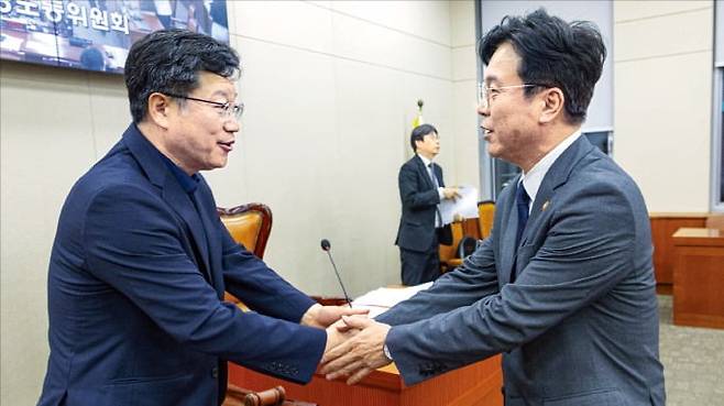 < 노란봉투법 통과되자 악수 > 더불어민주당 소속 안호영 국회 환경노동위원장(왼쪽)과 김영훈 고용노동부 장관이 28일 환노위 전체회의에서 ‘노란봉투법’﻿이 통과된 뒤 악수하고 있다.  연합뉴스