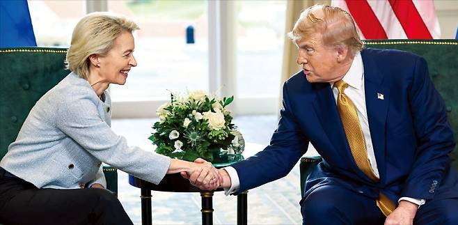 < EU도 관세 15% 타결, 트럼프 또 즉석 수정 > 도널드 트럼프 미국 대통령(오른쪽)과 우르줄라 폰데어라이엔 유럽연합(EU) 집행위원장이 27일(현지시간) 영국 스코틀랜드 턴베리 회담장에서 미·EU 무역 합의를 발표한 뒤 악수하고 있다. ﻿﻿