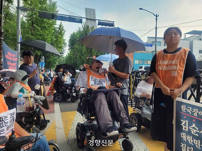 전국장애인차별철폐연대 활동가가 29일 국정기획위원회 앞에서 열린 기자회견 중 얼음물로 더위를 식히고 있다. 백민정 기자