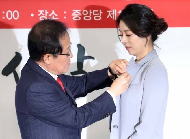 2018년 3월 9일 서울 여의도 자유한국당(국민의힘 전신) 당사에서 열린 영입인사 환영식에서 홍준표 당시 대표가 입당한 배현진 의원(당시 전 MBC 앵커)에게 태극기 배지를 달아주고 있다. 연합뉴스