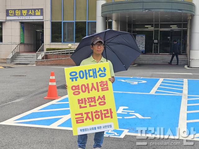 ▲지난달 24일 비 내리는 광주시교육청에서 박고형준 학벌없는사회를 위한 시민모임 활동가가 '유아대상 영어시험 반편성 금지'를 촉구하는 손팻말을 들고 1인 시위를 하고 있다.2025.06.24ⓒ프레시안(김보현)