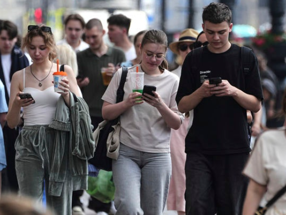 러시아 상트페테르부르크의 시민들이 걸어가면서 휴대폰을 보고 있다. AP 뉴시스