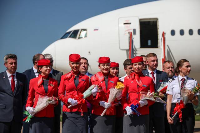 28일 북한 평양 순안국제공항에서 도착한 모스크바발 첫 직항 여객기 승무원들이 꽃다발을 받아 들고 있다. 연합뉴스