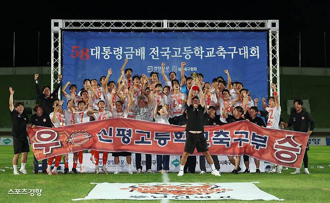 제58회 대통령금배 전국고교축구대회에서 우승한 충남 신평고 유양준 감독(가운데)과 선수들이 충북 제천종합운동장에서 27일 열린 시상식에서 트로피를 들어올리며 세리머니하고 있다. 제천 | 권도현 기자