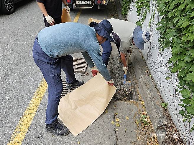 1일 오전 광주 남구 송하동 일대에서 남구청 하수도 준설원들이 빗물받이에 쌓인 흙, 낙엽 등을 삽으로 퍼내고 있다. 강주비 기자