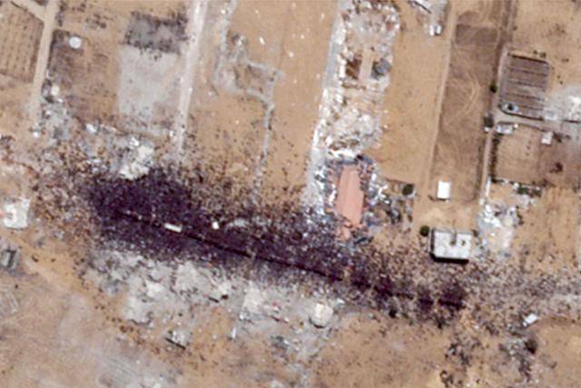 26일 민간 인공위성 업체 플래닛랩스가 촬영한 가자지구 남부 모라그 인근 회랑의 모습. 구호품 트럭 10대가 도착하자 새까만 인파가 몰려들었다. 가자=AFP 연합뉴스