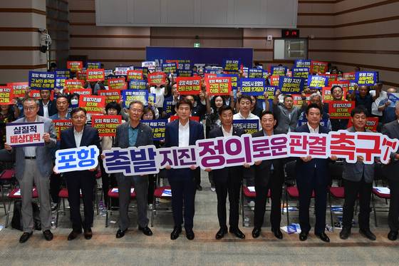지난달 12일 경북 포항시청 대회의실에서 열린 포항지진 대시민 토론회에 앞서 참석자들이 대구고법 항소심 기각 판결 항의하는 구호를 외치고 있다.   뉴스1