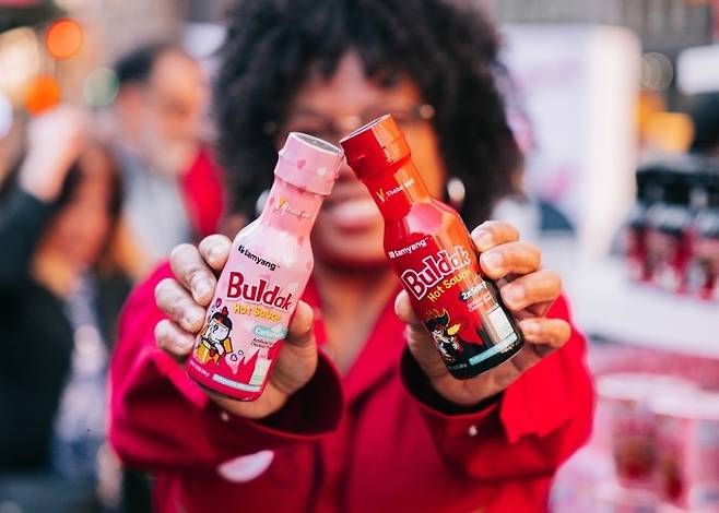 A customer holds bottles of Samyang's Buldak sauce at a food event in New York. (Samyang Roundsquare)