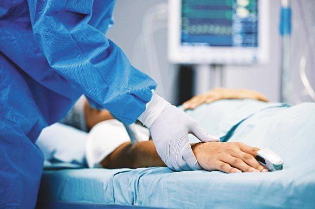 병상에 누워있는 환자를 돌보는 의료인의 손. 게티이미지뱅크