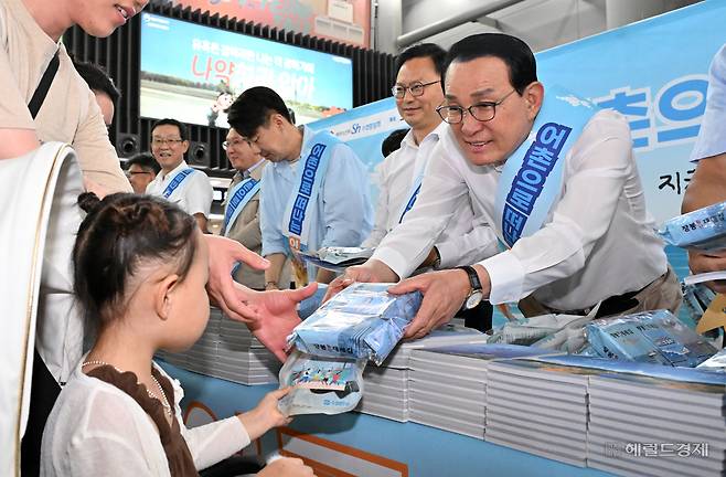 노동진(오른쪽 첫 번째) 수협중앙회장이 30일 서울 강남구 수서역에서 열린 ‘여름휴가 어촌에서 보내기 캠페인’에서 한 어린이에게 어촌마을을 소개하는 ‘바다를 보다’ 책자를 나눠주고 있다. 임세준 기자
