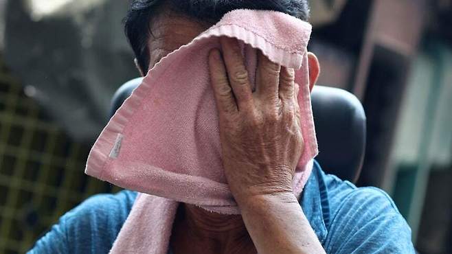 폭염이 이어지고 있는 29일 서울 동대문종합시장 인근에서 한 근로자가 원단을 옮긴 후 땀을 닦으며 휴식을 취하고 있다. 연합뉴스