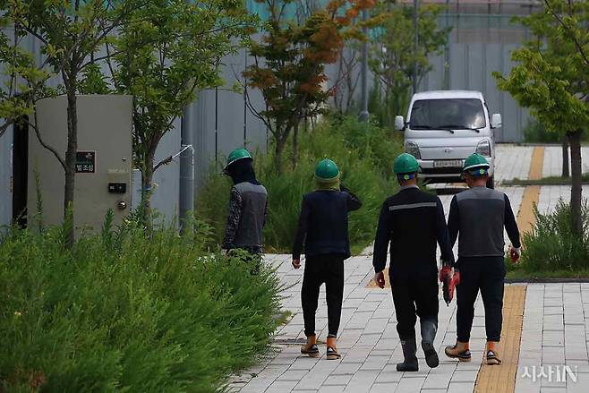 작업이 중지된 건설 현장에서 안전모를 쓴 노동자들이 이동하고 있다. ⓒ시사IN 이명익
