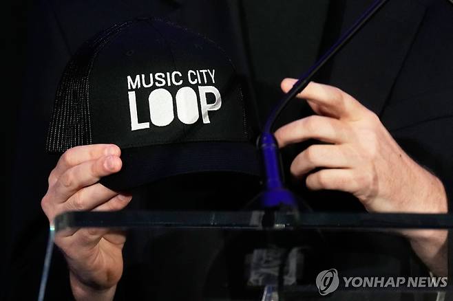 보링컴퍼니 CEO가 지난 28일 행사에서 '뮤직 시티 루프'라는 글자가 인쇄된 모자를 들고 있는 모습. [AP=연합뉴스. 재판매 및 DB 금지]