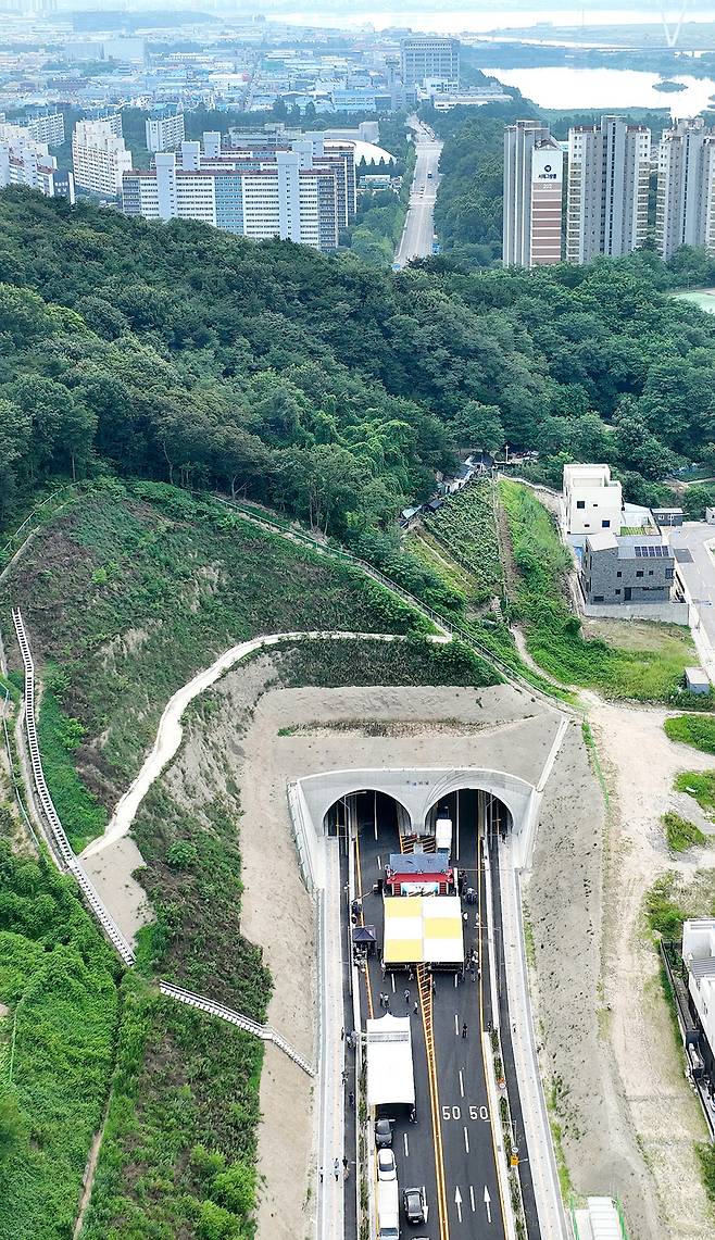 ▲ 인천 연수구 동춘동 소암마을과 대건고등학교를 잇는 도로가 8월1일부터 개통된다. 31일 개통을 앞두고 개통식행사 준비를 하고 있다. 봉재산으로 인해 단절돼 있던 동춘1·2 도시개발사업 구간의 기존 도로를 터널로 연결한 사업이다. 착공 이후 3년 만에 완공돼 인근 주민들의 통행 편의와 지역 간 접근성이 크게 향상될 것으로 기대된다. /양진수 기자 photosmith@incheonilbo.com