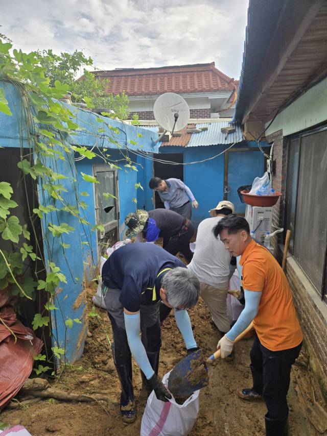 ▲계룡시청 직원들이 침수 피해를 입은 주택 앞에서 삽을 이용해 쌓인 토사를 정리하며 수해 복구 작업에 힘쓰고 있다.