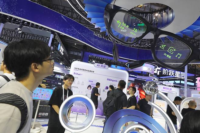 28일 중국 상하이에서 열린 2025 세계 인공지능 대회(WAIC)에서 관객들이 AI 기반 스마트 글래스 전시 부스를 살펴보고 있다. /연합뉴스