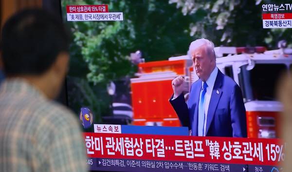 한국과 미국의 관세협상이 타결된 31일 서울역 대합실에서 한 시민이 관련 뉴스를 시청하고 있다. 연합뉴스