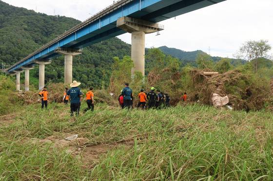 Police and fire authorities search the area where an body, presumed to be one of the missing people who were swept away by floods due to heavy rainfall on July 20, was discovered near Sincheongpyeong Bridge in Gapyeong, Gyeonggi, on July 31. [GYEONGGI NORTHERN FIRE AND DISASTER HEADQUARTERS]