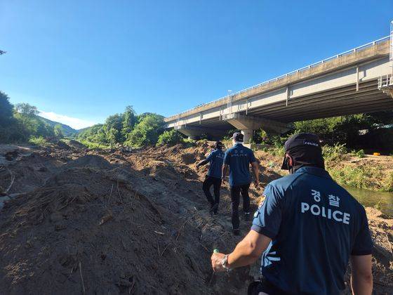 Officials from the Gyeonggi Northern Police Agency search for a missing person in the Jojongcheon Valley in Deokhyeon-ri, Gapyeong, Gyeonggi, on July 27. [OH SO-YEONG]