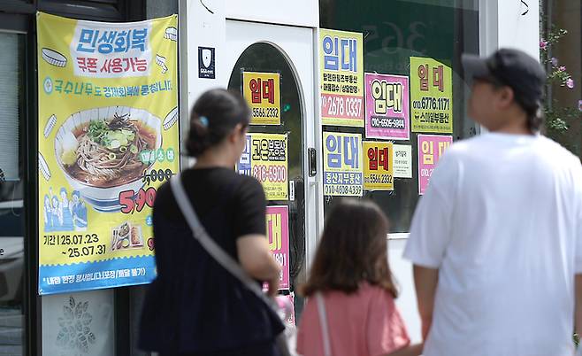 민생회복 소비쿠폰 지급 후 첫 주말인 27일 경북 경산시 한 상가에 민생회복 쿠폰 사용처라는 안내 현수막이 붙어 있다. [사진 = 연합뉴스]