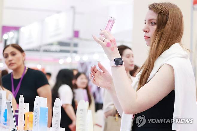 K뷰티 인기 (서울=연합뉴스) 진연수 기자 = 28일 서울 강남구 코엑스에서 열린 2025 서울국제화장품미용산업박람회 및 국제건강산업박람회를 찾은 외국인 바이어가 제품을 살펴보고 있다. 2025.5.28 jin90@yna.co.kr