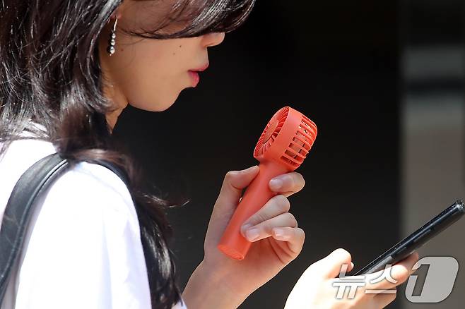 폭염이 계속된 1일 대구 중구 동성로에서 한 시민이 휴대용 선풍기 바람을 맞으며 발걸음을 옮기고 있다. 2025.8.1/뉴스1 ⓒ News1 공정식 기자
