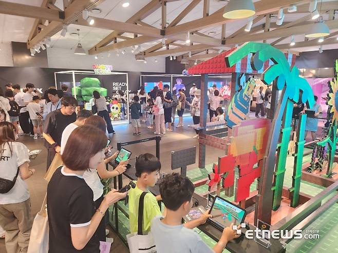 판교 현대백화점 지하 1층에 마련된 로블록스 팝업 스토어에서 방문객이 게임을 즐기고 있다.
