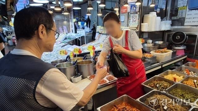 수원 못골종합시장에서 한 시민이 장을 보고 신용카드를 내밀고 있다. 경기일보DB