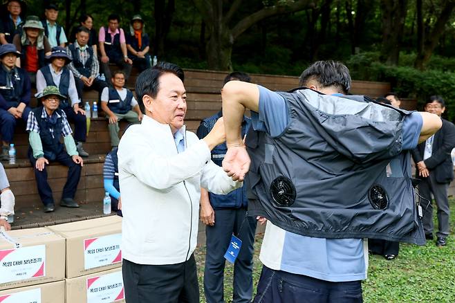 이성헌 서대문구청장(왼쪽)이 직원에게 보내조끼를 입히고 있다.