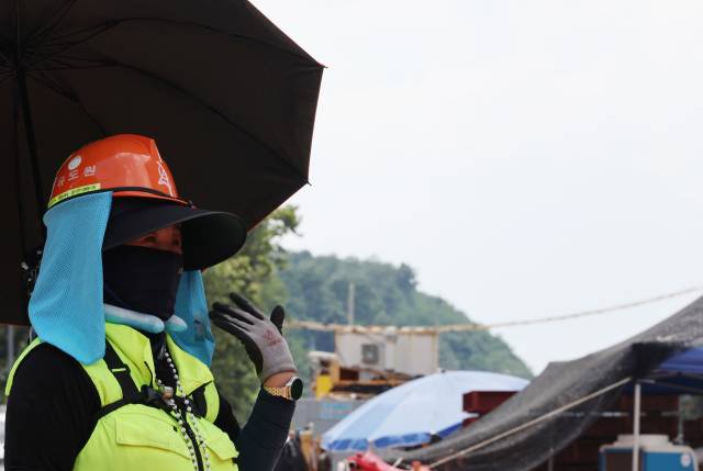 ▲폭염이 이어진 31일 서울 강남구 양재대로 개선사업 공사현장에서 한 근로자가 넥쿨러, 냉풍자켓 등 온열질환 예방용품을 착용하고 근무하고 있다. ⓒ연합뉴스