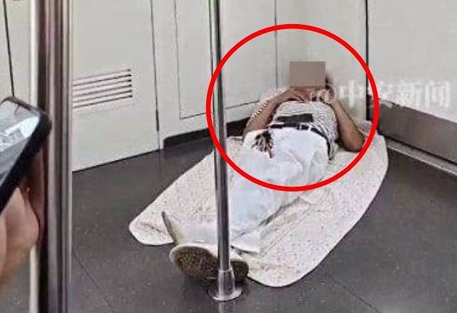 지난달 28일(현지시간) 중국 후베이성 우한시의 한 지하철 안에서 이불을 깔고 누워 잠이 든 남성의 모습. 신징바오 제공