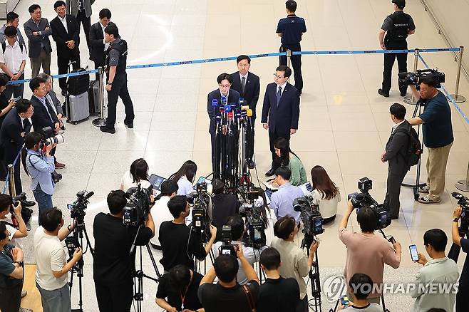 취재진 질문에 답하는 김정관 장관 (서울=연합뉴스) 김도훈 기자 = 미국과의 무역협상을 마친 김정관 산업통상부장관이 1일 인천국제공항 제2여객터미널을 통해 귀국해 취재진 질문에 답하고 있다. 
    왼쪽부터 김정관 장관, 구윤철 경제부총리, 여한구 통상교섭본부장. 2025.8.1 superdoo82@yna.co.kr