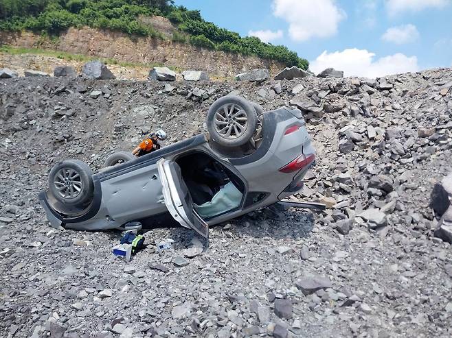 지난해 8월 2일 경남 사천시 한 채석장 내 비포장 도로에서 스포츠유틸리티(SUV) 차량이 추락해 전복돼 있다. 이 사고로 2명이 사망했다. 경남소방본부 제공
